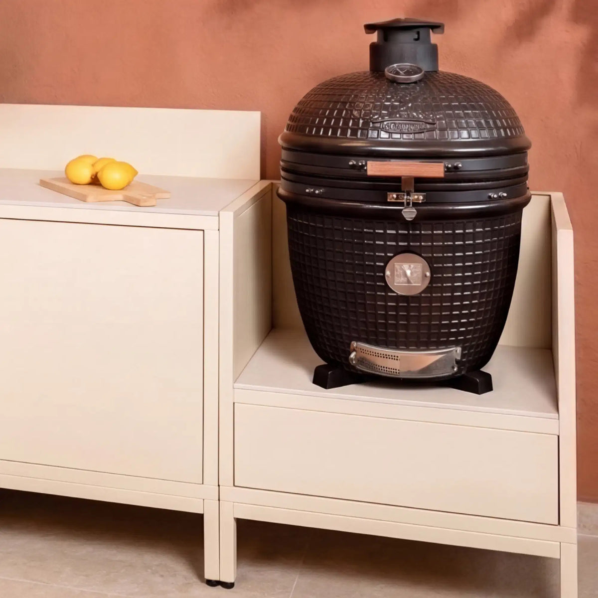 Outdoor-Küche Pilotis in Cremeweiß mit Kamado-Modul und Arbeitsplatte aus weißer Keramik.\n::visuel:creme
