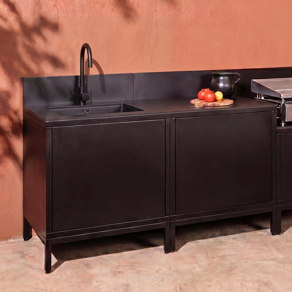 Cuisine extérieure Pilotis noir profond avec module évier, plan de travail en céramique noire et plancha
::visuel:noir