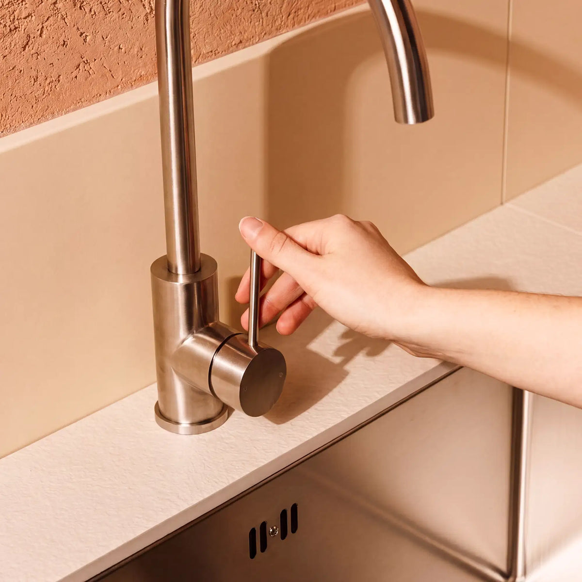 Robinet en inox installé sur un module évier Pilotis avec plan de travail en céramique blanc crème
::visuel:creme