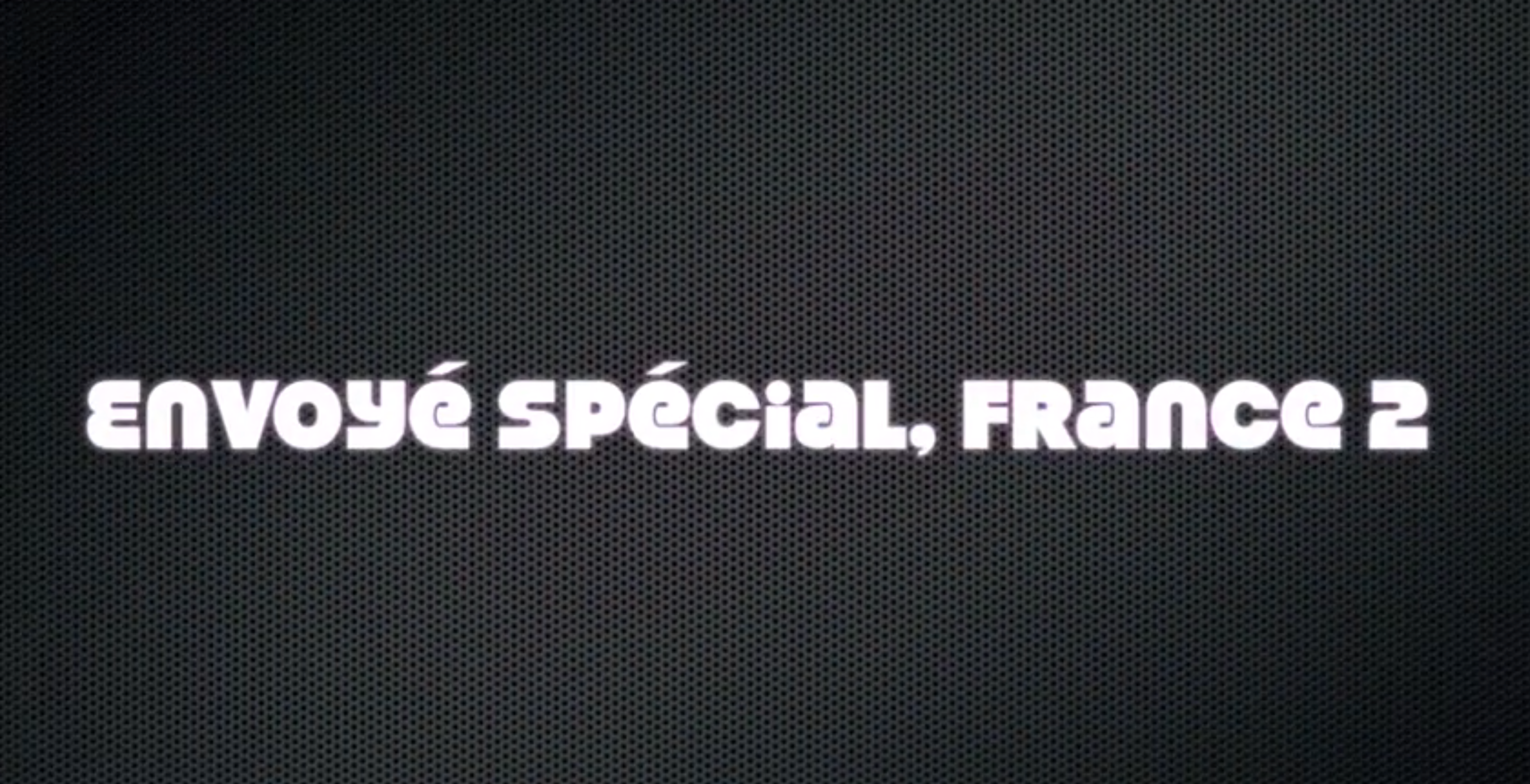 Einführungsbildschirm mit dem Text „Envoyé spécial, France 2“ auf einem dunklen, strukturierten Hintergrund.