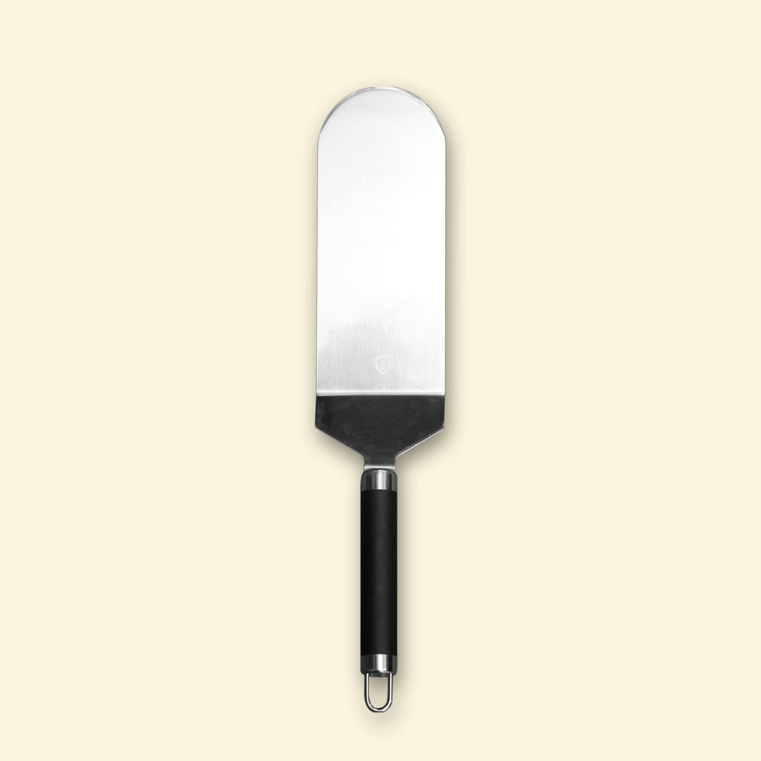 Grande spatule à poisson en inox avec manche noir, présentée sur fond beige.